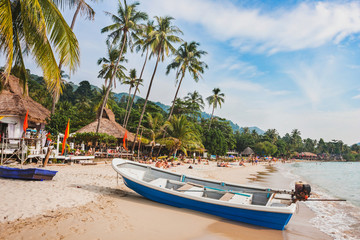 Obraz na płótnie Canvas beautiful tropical beach in Thailand, wooden boat and palm trees on Koh Chang