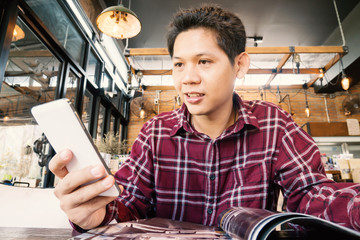 Asian man using smartphone in the coffee shop