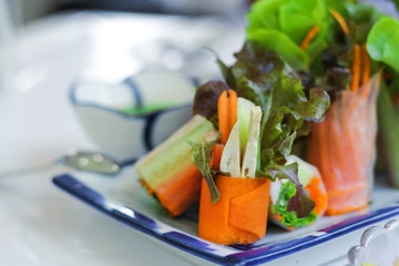 Fresh spring rolls or salad rolls made with fresh vegetable, crab stick and Vietnamese rice paper, serve with spicy salad cream dipping on glass plate