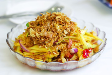 yellow mango salad with oyster and shallot garnish with crispy shallot