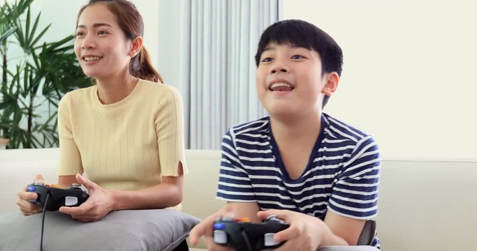 Happy asian family play game with smile face at home. Thai sister and brother playing game together .