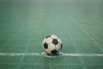 Grunge football on green plastic court
