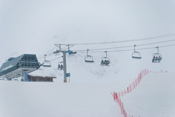 Ski chairlift going up snow covered mountain to top