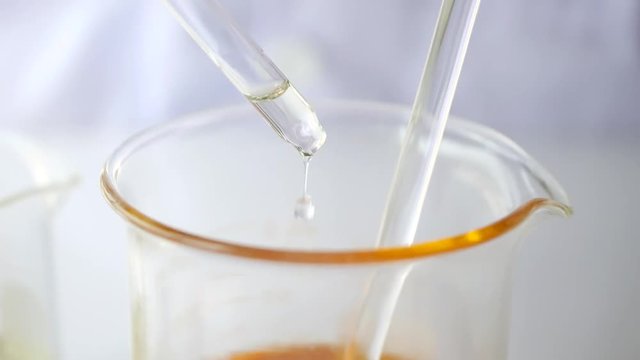 the sciencetist drop and measure  the oil in the laboratory for natural cosmetic skincare and herbal medicine . 