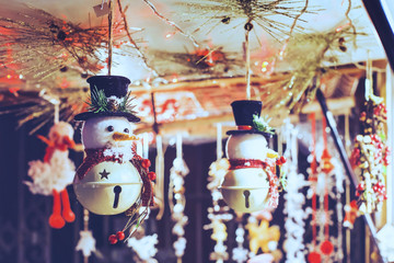 snowman toy decoration in christmas market in european city by night