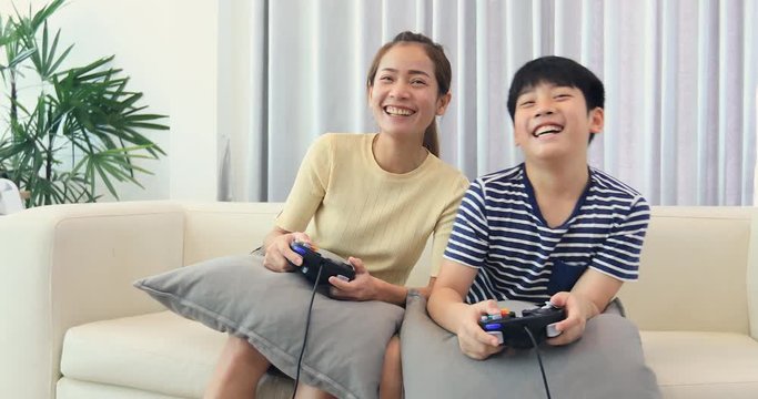 Happy asian family play game with smile face at home. Thai sister and brother playing game together .