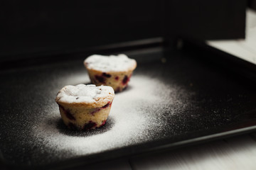Delicious berry muffins with powdered sugar