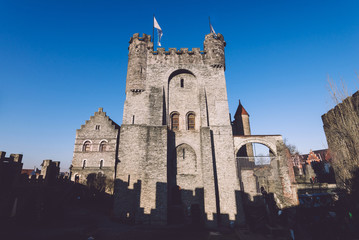 Fototapeta premium Ghent, Flanders, Belgium - December 30th, 2016. Gravensteen - historical medieval castle in flemish capital Gent. Castle of Counts stronghold by golde hour.