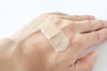 Adhesive bandage on hand against white background