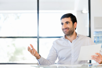 Handsome young man holding paper in office