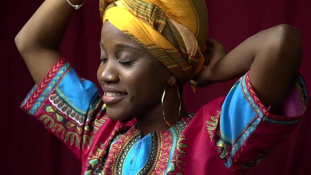 Beautiful black woman in traditional African clothes posing in studio, slow motion