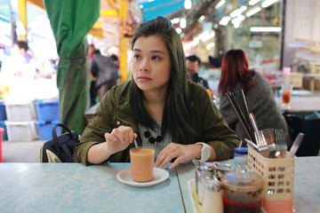 girl have breakfast in the cafe in chinese asian wet market