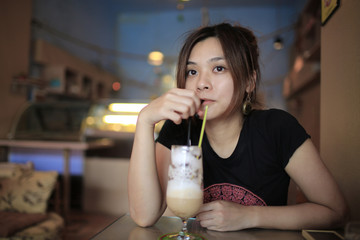 girl is relax to drink the milk coffee, she take her time in the tea time in summer