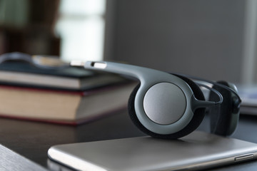 Headphones with book and mobile phone on wood table