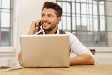 lächelnder mann mit handy und notebook