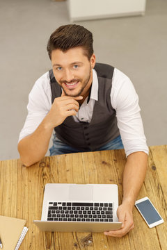 lächelnder mann arbeitet am laptop