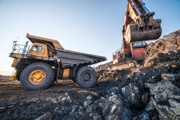 type of coal mine with working excavators and large cars
