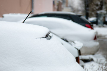 The first snow on cars in the city in the autumn day