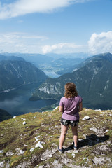 Naklejka premium Beautiful young woman looking at the lake in the mountains