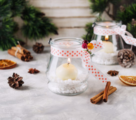 glass New Year candle holders with candles on a wooden white table, selective focus