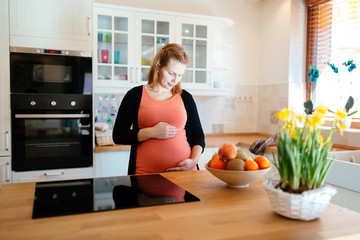 Beautiful pregnant woman in kitchen