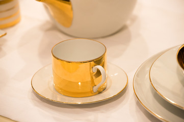 Cup on saucer served on white table cloth