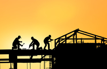 silhouette construction team working on blurry sunset time