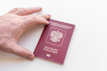 Man's hand holds a Russian passport on a white background. Isolated