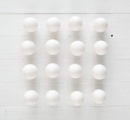 White raw eggs n rows on a white wooden table