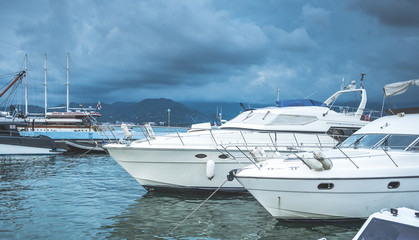 Fototapeta premium Yachts moored in port of Batuni, Georgia with view on mountains in fog.