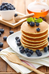 Mixed berry pancake with honey on wooden table