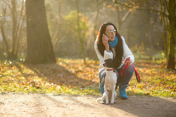 Young woman walking with her dog in autumn Park.