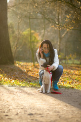 Obraz premium Young woman walking with her dog in autumn Park.