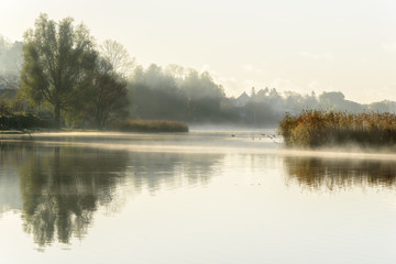 Misty autumn morning with reflections in the water