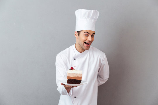 Portrait of a smiling excited male chef dressed in uniform