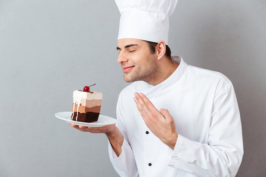 Portrait of a satisfied male chef dressed in uniform