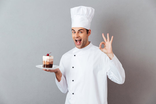 Portrait of a cheery happy male chef dressed in uniform
