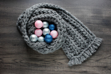 Obraz na płótnie Canvas Christmas balls on knitted scarf