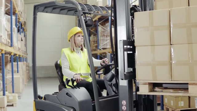 Female warehouse worker with forklift.