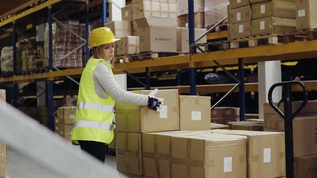 Female warehouse worker loading boxes.