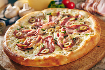 Pizza Restaurant Menu - Delicious Fresh Pizza with Bacon and Olives. Pizza on Rustic Wooden Table with Ingredients