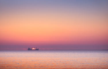Naklejka na ściany i meble boat in the sea at sunset