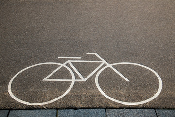 Fototapeta na wymiar Bicycle white sign or icon on the asphalt road in the city