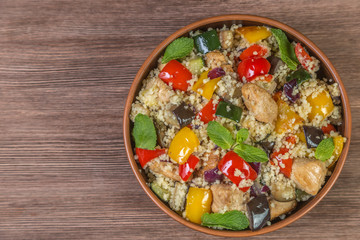 Tabbouleh salad with roasted vegetables, chicken and couscous. Close-up. The view from the top....