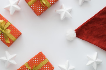 Christmas and New Year holiday composition with gift boxes, santa hat, ribbons, stars on the white background. Top view, flat lay. Copyspace.