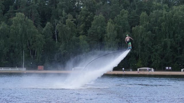 Man on flyboard spins round above the water surface