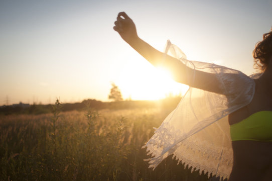 Junge Frau im Sommer auf dem Feld im Kleid
