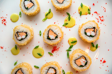 Sushi rolls scattered on white background