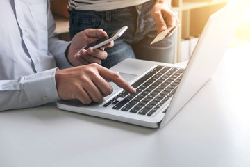 Man using smart phone and credit/debit card register payments online shopping and customer service network connection market, using technology on laptop, Internet Online shopping or banking concept