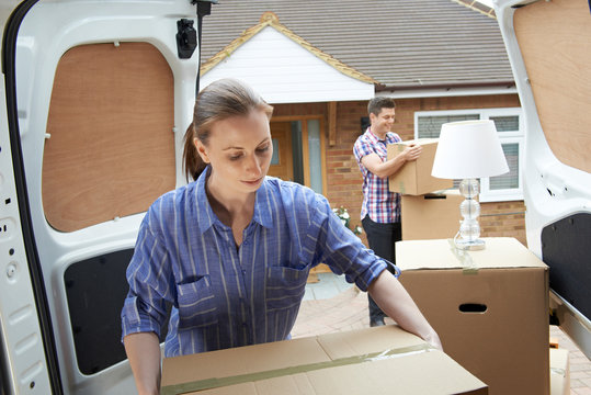 Young Couple Moving In To New Home  Unloading Removal Van